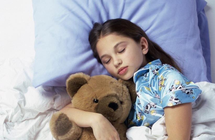Girl sleeping with a teddy bear (photo credit: INGIMAGE)