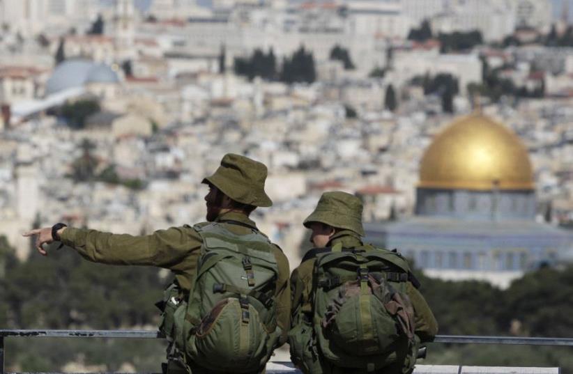 IDF soldiers stand at a lookout point on the Mount of Olives, overlooking the Dome of the Rock in Jerusalem's Old City (photo credit: REUTERS)