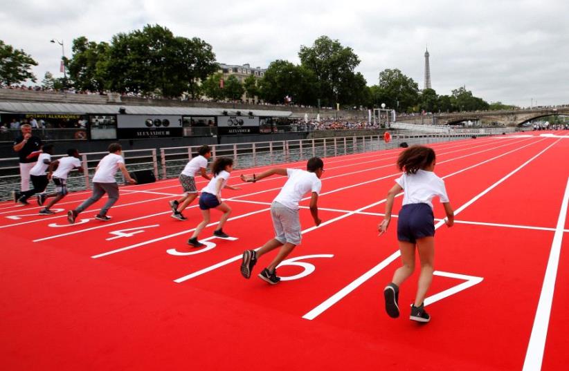 Children take the start in a 100m race on an athletics track installed on the River Seine in Paris, France, June 23, 2017. (photo credit: REUTERS)