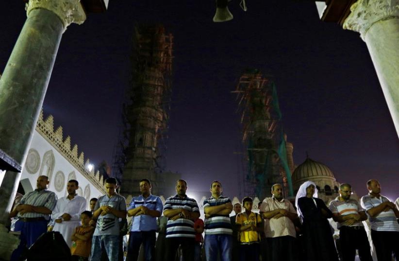 Egyptian Muslims take part in evening prayers called "Tarawih" on Laylat al-Qadr or Night of Decree, at Al-Azhar Mosque in old Cairo, Egypt June 21, 2017. (photo credit: REUTERS)