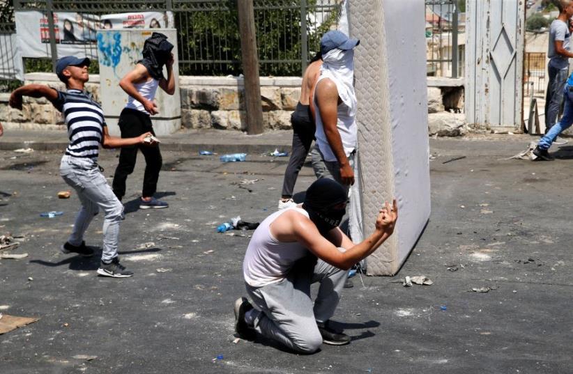 Palestinians clash with Israeli security outside the Old City of Jerusalem (photo credit: REUTERS/AMMAR AWAD)