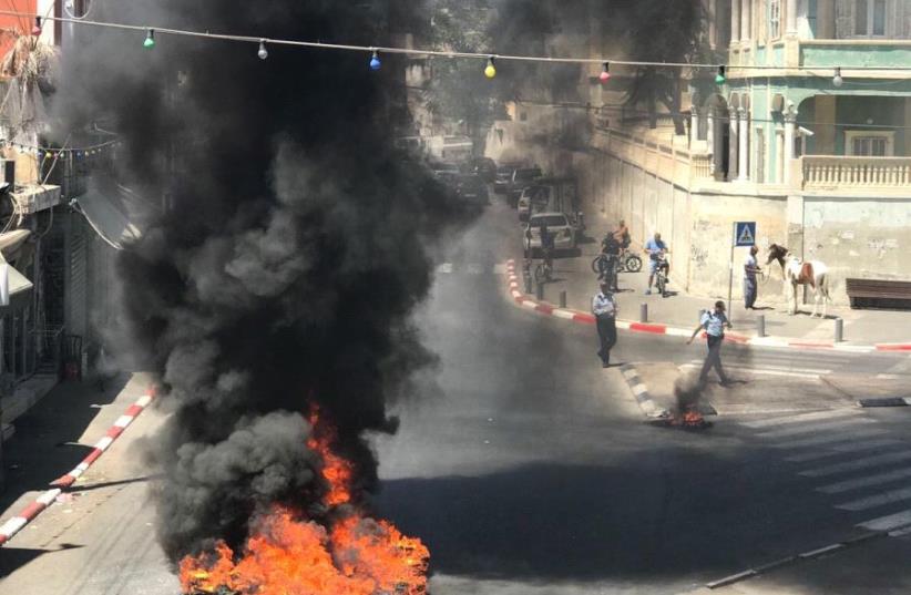 Protestors burn tires during clashes with police in Jaffa, July 29, 2017. (photo credit: SOCIAL MEDIA)