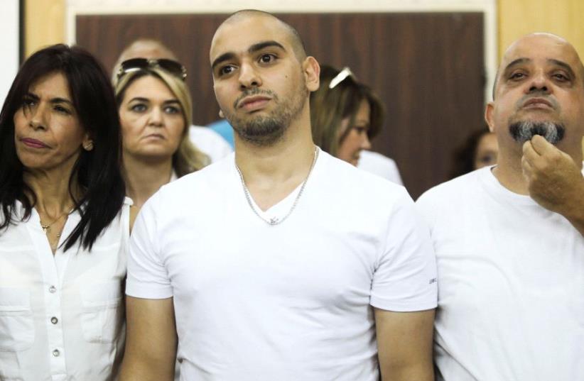 Former Israeli soldier Elor Azaria (C), who was convicted of manslaughter and sentenced to 18 months imprisonment for killing a wounded and incapacitated Palestinian assailant, waits to hear the ruling at an Israeli military appeals court in Tel Aviv, Israel July 30, 2017.  (photo credit: REUTERS)
