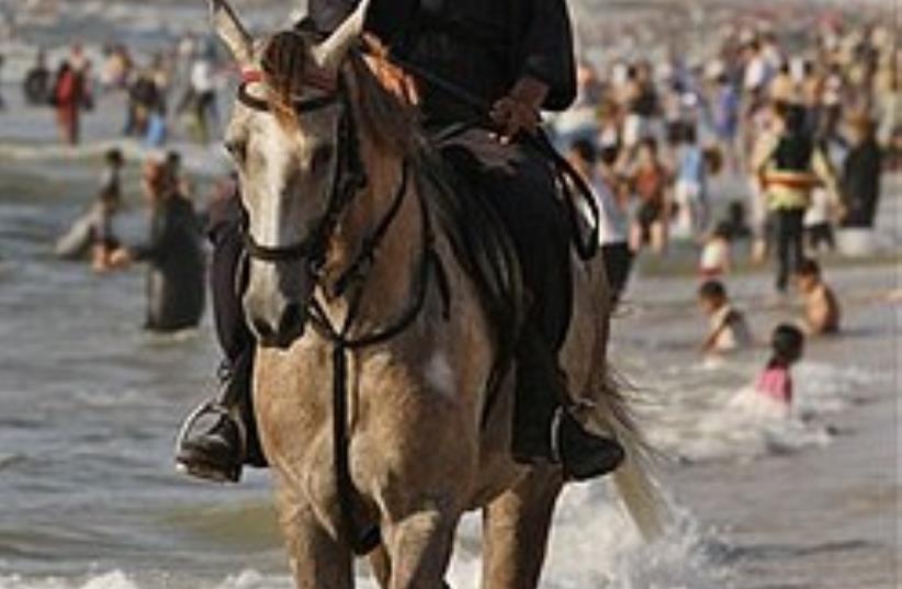 A Mounted Hamas security officer patrols the beach (photo credit: AP)