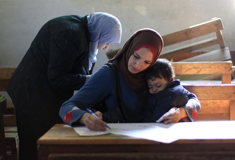 Egyptian woman reads ballot (Reuters)