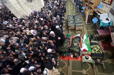 Palestinian worshipers near bodies of dead Islamic Jihad members (Reuters)
