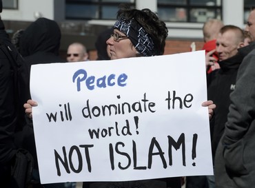 A woman holds an anti-Islamic banner in Denmark rally (Reuters)