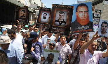 Palestinians in Ramallah hold prisoners' pictures