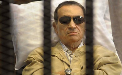 Former Egyptian President Hosni Mubarak sits inside a cage in a courtroom in Cairo (Reuters)