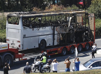 Truck carries bus damaged in terrorist attack
