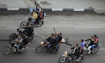 Gunmen ride motorcycles dragging body of alleged collaborator