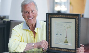 PAT BOONE holds up the framed Christmas card on which he wrote the lyrics to his song.