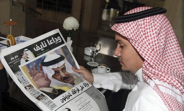 A man reads a newspaper in Jeddah June 17, 2012