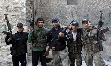 Brothers who are members of a rebel group called Martyr Al-Abbas pose for a picture in Aleppo.