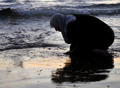 A woman prays at the shore in Tel Aviv during Id al-Fitr celebrations (Hadas Parush)
