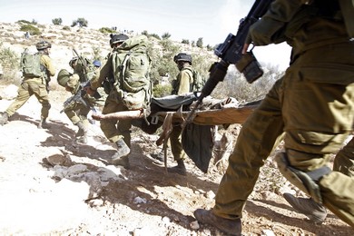 Israeli soldiers carry away the body of armed Palestinian militant Mohammed Assi near the West Bank village of Bilin, near Ramallah October 22, 2013 (Reuters)