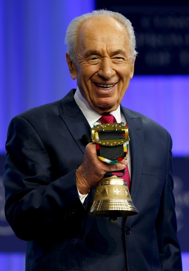 Peres holds his award.