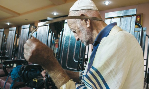 A Jewish man wraps teffilin at the Central Synagogue in Havana.