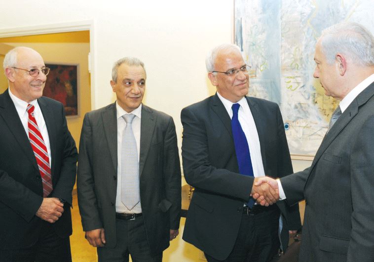 Netanyahu shakes hands with member of the Palestinian Parliament Dr. Saeb Erekat in Jerusalem in April 2012. On the far left side, is Attorney Yitzhak Molcho. (GPO)