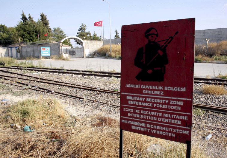 A Turkish military warning sign, with the closed Karkamis border gate in the background, is pictured in Karkamis, bordering with the Islamic State-held Syrian town of Jarablus, in Gaziantep province, Turkey
