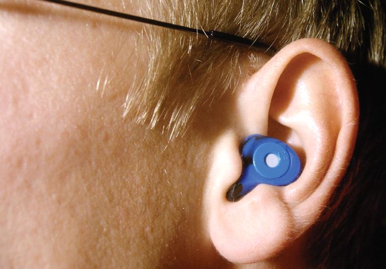 Custom-fitted silicon earplug worn by a musician for protection from loud sounds during performances