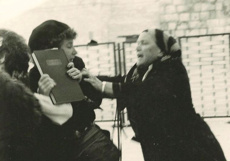 A woman tries to snatch a prayer book from a member of WOW in 1989 by the Kotel (photo credit: BARBARA GINGOLD. COURTESY OF SHULAMIT MAGNUS)
