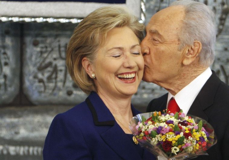 Shimon Peres kisses then US Secretary of State Hillary Clinton as he gives her flowers after their meeting in Jerusalem, March 2009 (photo credit: REUTERS)