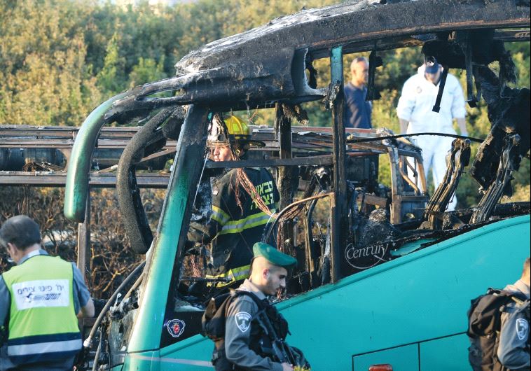 Border policemen and firefighters stand near a bus that was bombed in a terrorist attack in Jerusalem in April (photo credit: MARC ISRAEL SELLEM)