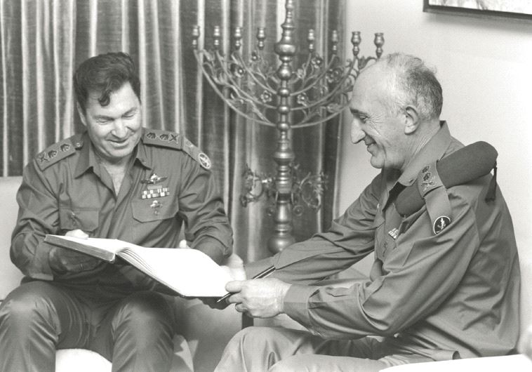 Outgoing Chief of Staff Moshe Levy (right) and incoming chief of staff Dan Shomron holding the guest book during the ceremony at the President’s Residence in Jerusalem (photo credit: HARNIK NATI/GPO)