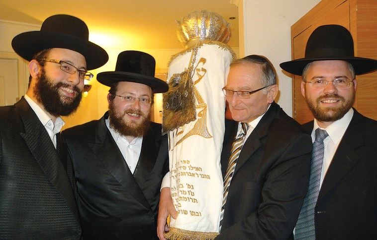 DAVID BRAGER holds his father’s Torah scroll during its rededication at the Yeshivat Keter HaTalmud in Jerusalem in 2011. (Courtesy)