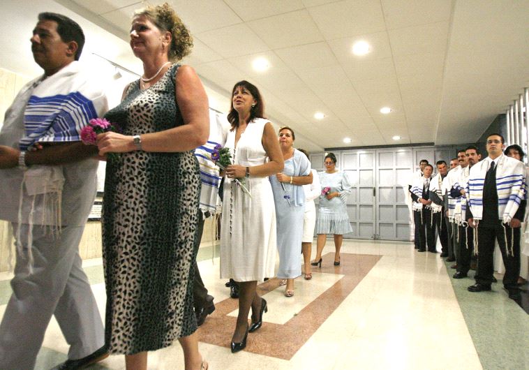 Grooms wearing tallitot [prayer shawls] enter the Beth Shalom synagogue with their brides during a wedding ceremony (photo credit: REUTERS)
