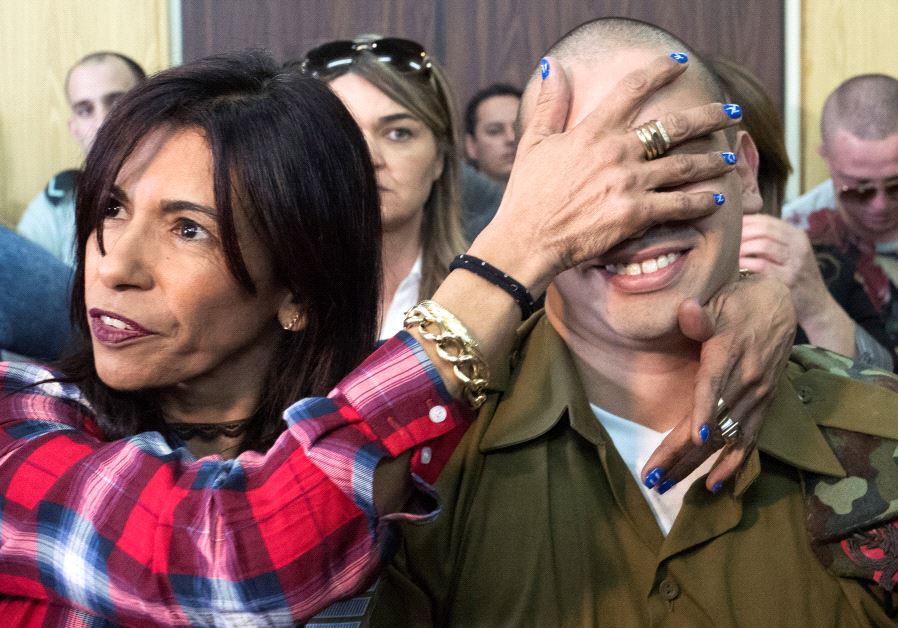Elor Azaria is embraced by his mother as his father stands nearby, at the start of is sentencing hearing at a military court in Tel Aviv, Israel February 21, 2017 (Reuters)