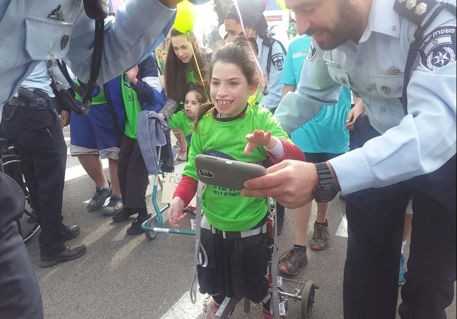 Volunteers help children with disabilities participate in the Jerusalem Marathon. (photo credit: COURTESY OF ALEH)