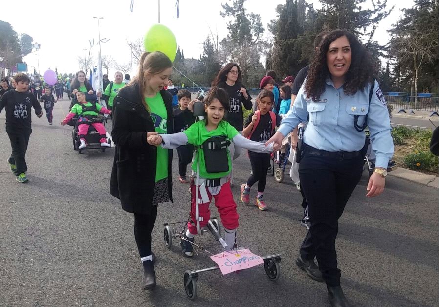  Volunteers help children with disabilities participate in the Jerusalem Marathon. (photo credit: COURTESY OF ALEH)