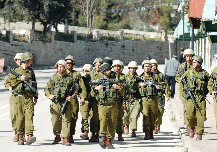 IDF soldiers patrol after clashes with Hebron Jews seeking to thwart evacuation from the city’s wholesale market in 2006 (AVI OHAYON/GPO) 