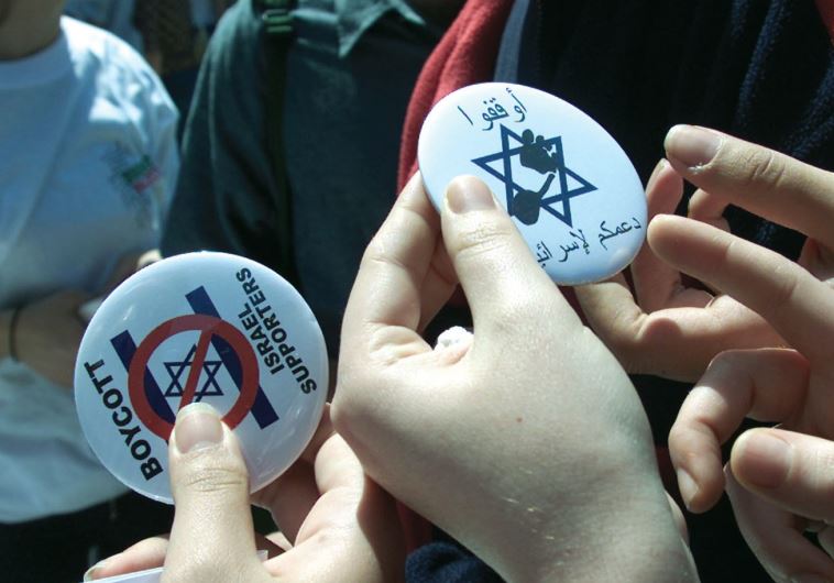 WOMEN HOLD pins that advocate a boycott against Israel