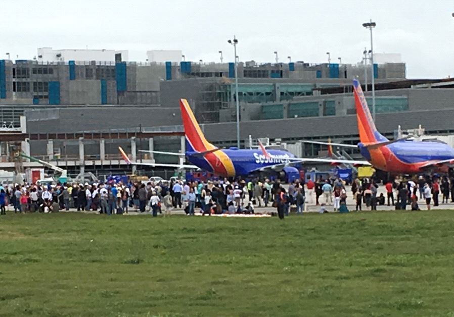 Travelers are evacuated out of the terminal and onto the tarmac after a shooting at Fort Lauderdale-