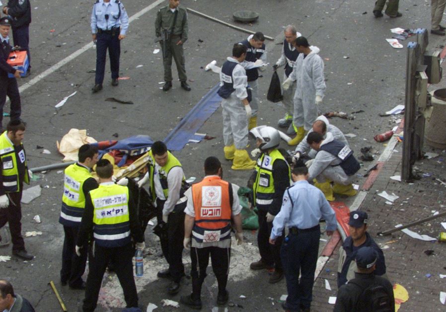 Investigators surround the body of a suicide bomber following an explosion near the Sbarro pizzeria 