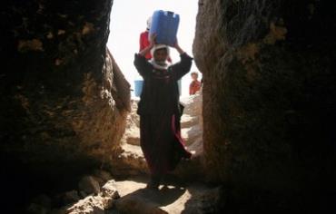Palestinian woman carrying water