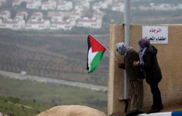 Palestinians hold a flag in the West Bank