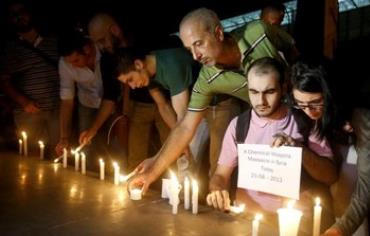 Syrian civilians take part in a candlelight vigil in solidarity with Syrian civilians killed.