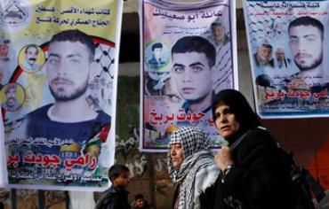 Gaza woman walks past posters of Palestinian prisoners