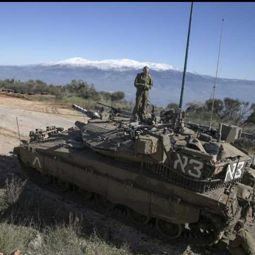 An IDF soldier stands atop a tank near the Lebanese border (credit: REUTERS)