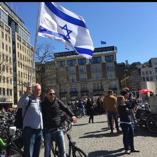 Pastor Stan Kamps waving the Israeli flag in Amsterdam as part of a campaign to fight anti-Semitism in Europe and show solidarity with European Jewry (credit: Courtesy)