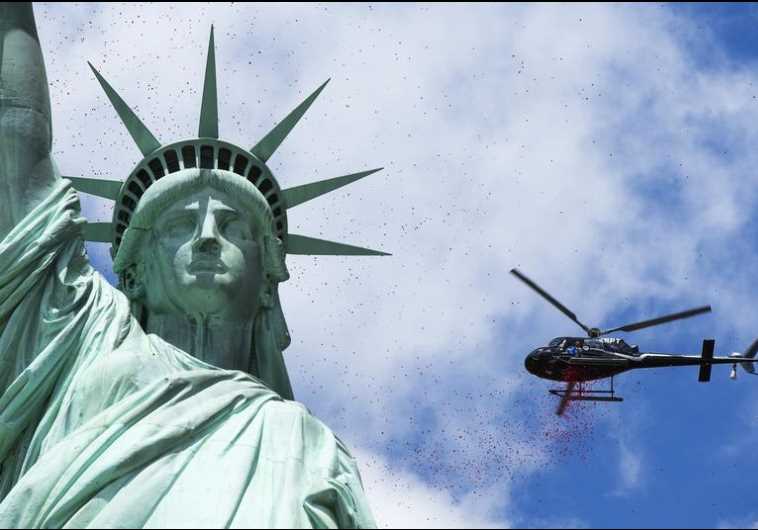 A helicopter flies above the Statue of Liberty in New York Harbor (credit: REUTERS)