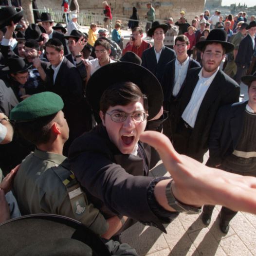 An ultra-orthodox Hassidic Jew is restrained by a Border Policeman as he screams against a group of Reform and Conservative rabbis holding prayers at the Western Wall (credit: REUTERS)