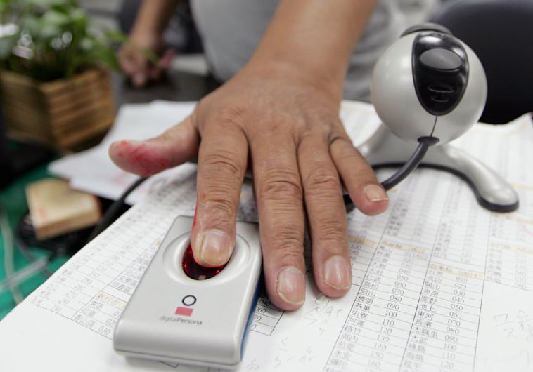 A man has his fingerprint scanned [file] (credit: REUTERS)