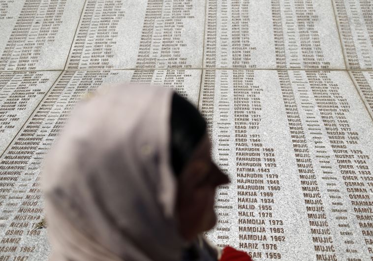 A woman stands in front of the Memorial Center during a reburial ceremony of 136 newly identified victims in Potocari, near Srebrenica, Bosnia and Herzegovina