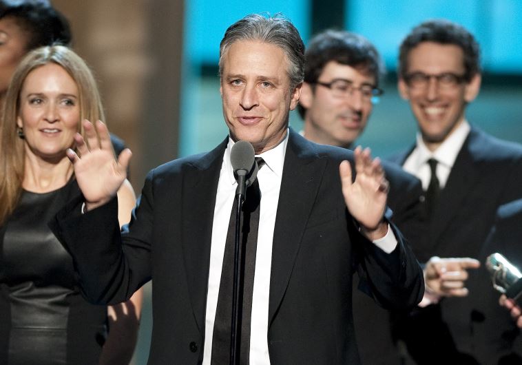 Talk show host Jon Stewart, flanked by his writers and correspondents, speaks after receiving the Best Late Night Comedy Series Award for his show (credit: REUTERS)