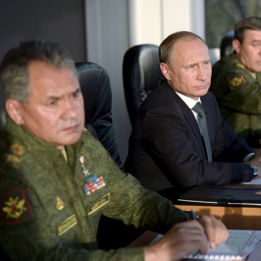 Russian President Vladimir Putin (C) with Defence Minister Sergei Shoigu (L) and armed forces Chief of Staff Valery Gerasimov observe troops during a training exercise
